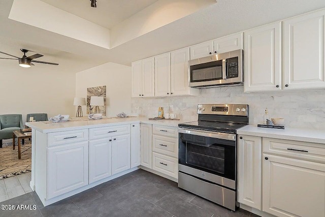 kitchen with ceiling fan, white cabinetry, appliances with stainless steel finishes, and kitchen peninsula