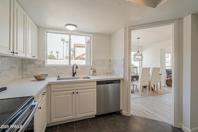 kitchen featuring white cabinets, stainless steel appliances, sink, backsplash, and hanging light fixtures