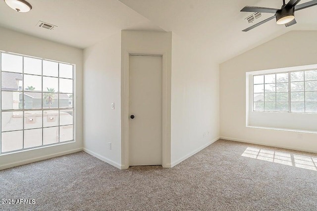 spare room featuring ceiling fan, light carpet, and vaulted ceiling