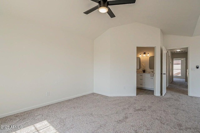 unfurnished bedroom featuring ceiling fan, light colored carpet, vaulted ceiling, and ensuite bathroom