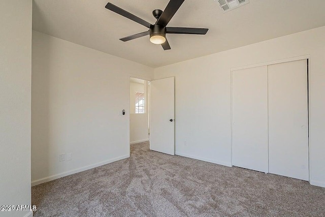 unfurnished bedroom with ceiling fan, light colored carpet, and a closet