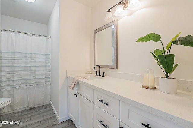 bathroom with vanity, toilet, and hardwood / wood-style floors