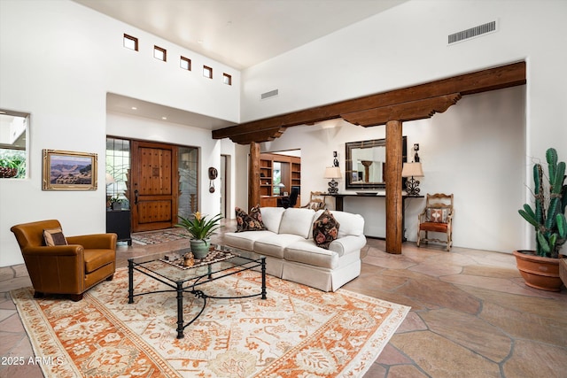 living area with visible vents, recessed lighting, a towering ceiling, and stone tile flooring