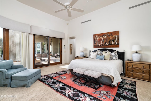 bedroom with carpet floors, arched walkways, access to outside, and visible vents
