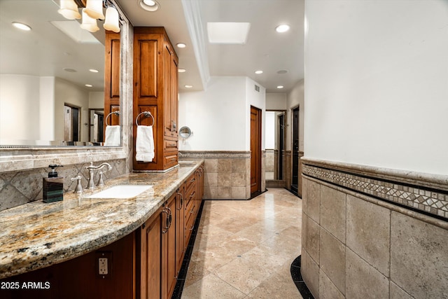 bathroom featuring tile walls, a wainscoted wall, vanity, and recessed lighting