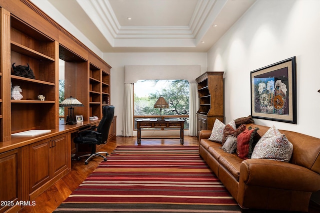 office space with crown molding, dark wood finished floors, built in desk, a raised ceiling, and recessed lighting