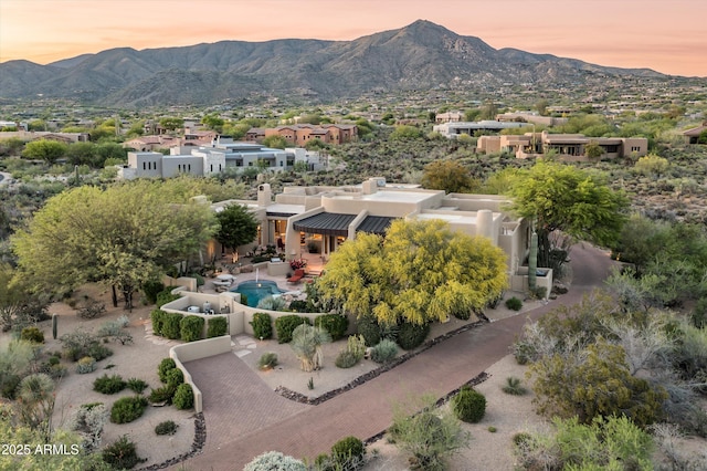 aerial view at dusk featuring a residential view and a mountain view