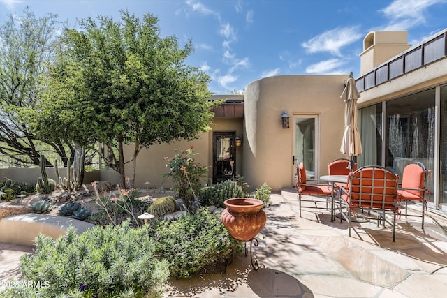 back of property featuring a patio and outdoor dining area