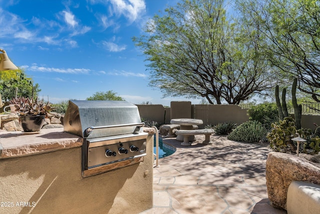view of patio with an outdoor kitchen, fence, and grilling area