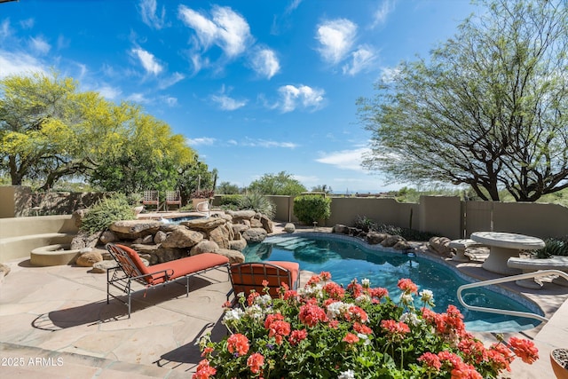 view of swimming pool featuring a fenced backyard, a fenced in pool, an in ground hot tub, and a patio area
