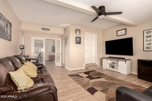 living room featuring ceiling fan, light hardwood / wood-style flooring, and beamed ceiling