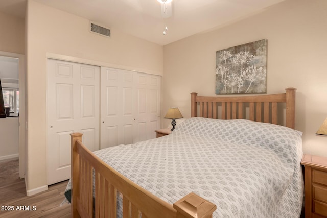 bedroom with ceiling fan, a closet, and light hardwood / wood-style flooring