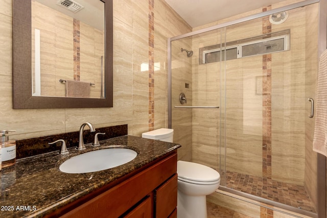 bathroom with toilet, an enclosed shower, and vanity