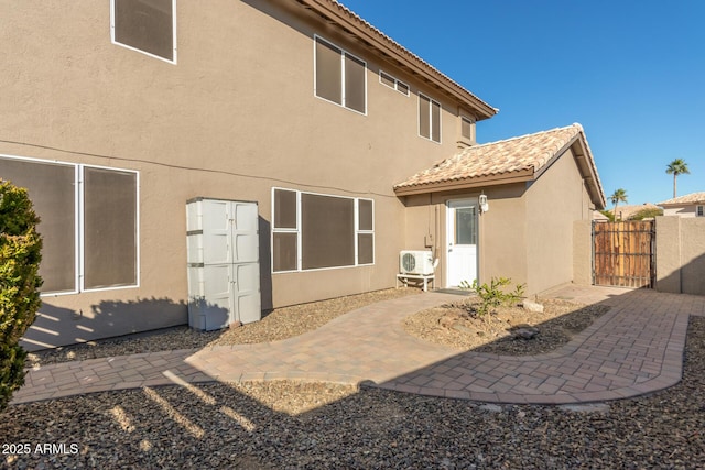 rear view of property featuring ac unit and a patio area