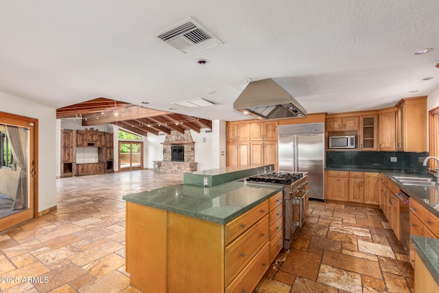 kitchen with backsplash, sink, built in appliances, a kitchen island, and island exhaust hood