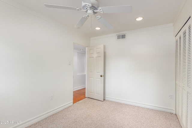 unfurnished bedroom with light carpet, a closet, ornamental molding, and ceiling fan