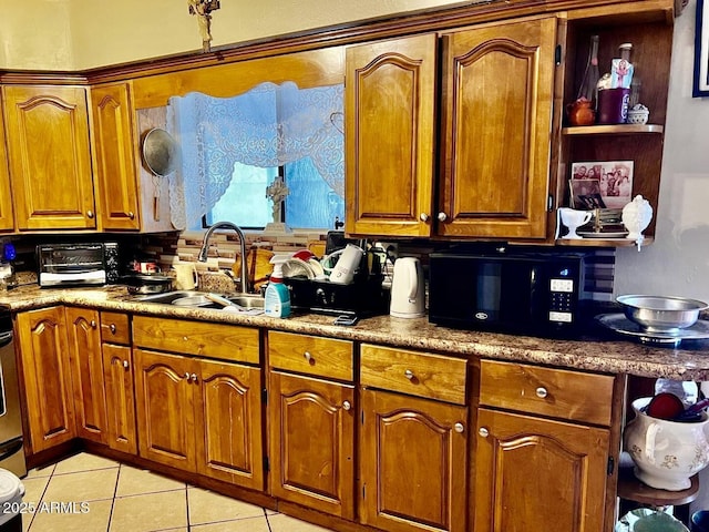 kitchen with range, light tile patterned floors, and sink