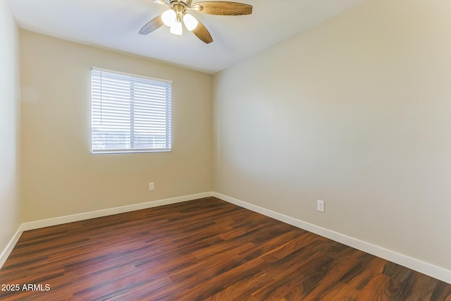 empty room featuring a ceiling fan, baseboards, and dark wood-style flooring