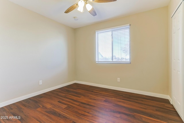 empty room with dark wood-style flooring, ceiling fan, and baseboards