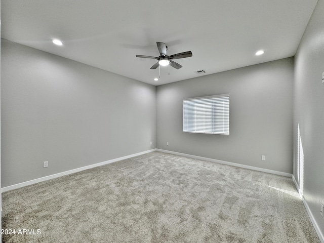 unfurnished room with ceiling fan and carpet