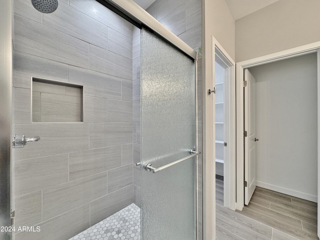 bathroom featuring a shower with door