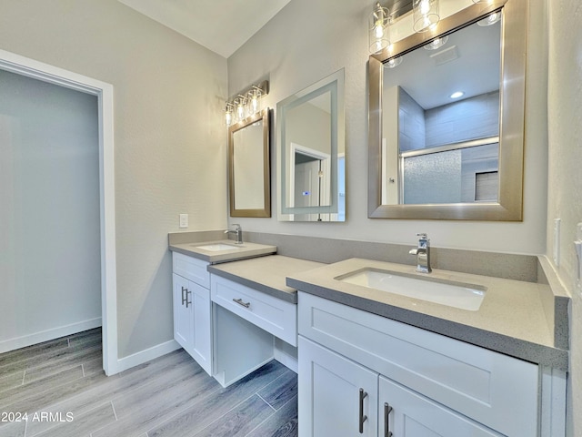 bathroom with hardwood / wood-style floors, vanity, and walk in shower