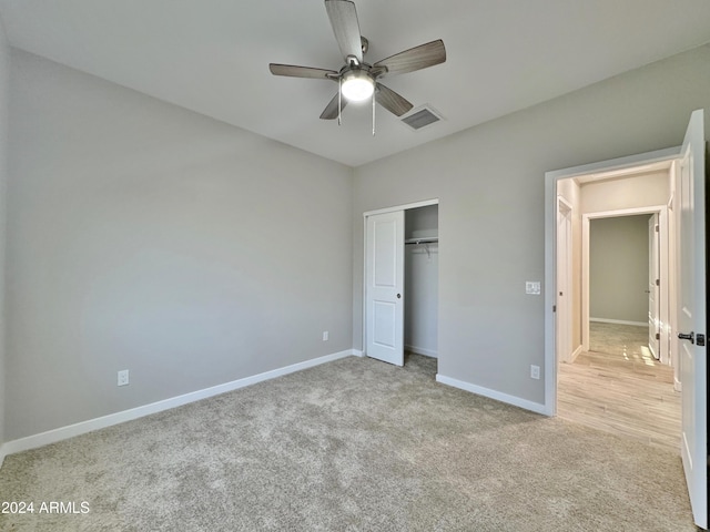 unfurnished bedroom with ceiling fan, a closet, and light colored carpet