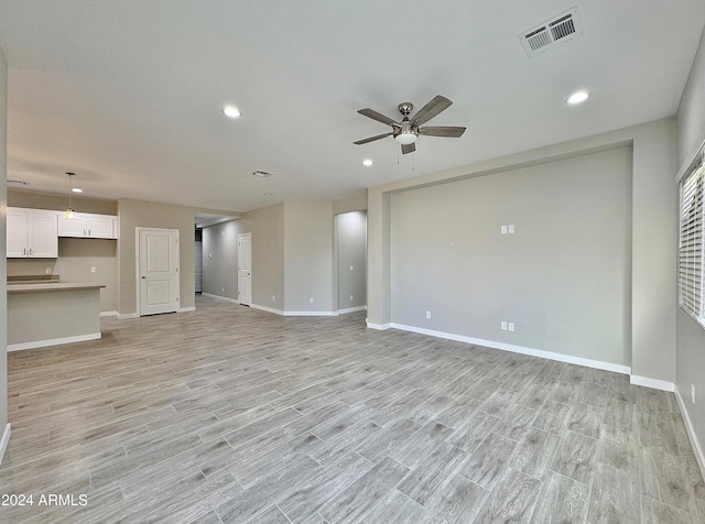 unfurnished living room with ceiling fan and light hardwood / wood-style flooring