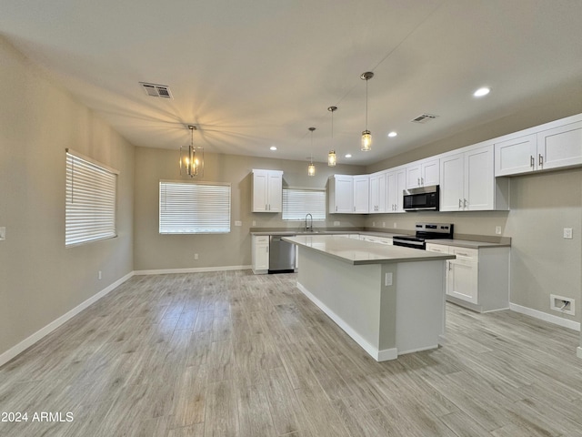 kitchen with white cabinets, a center island, and stainless steel appliances