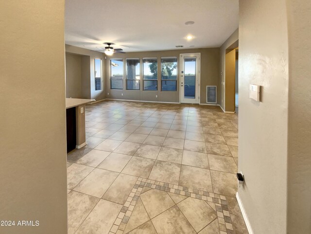 tiled spare room with ceiling fan