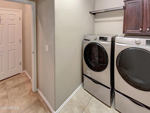 laundry room featuring cabinets, independent washer and dryer, and light tile patterned flooring