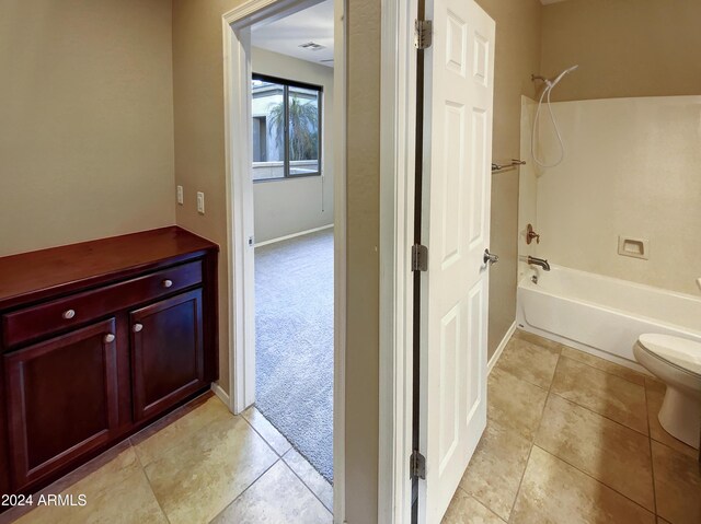 bathroom featuring shower / tub combination, tile patterned flooring, and toilet