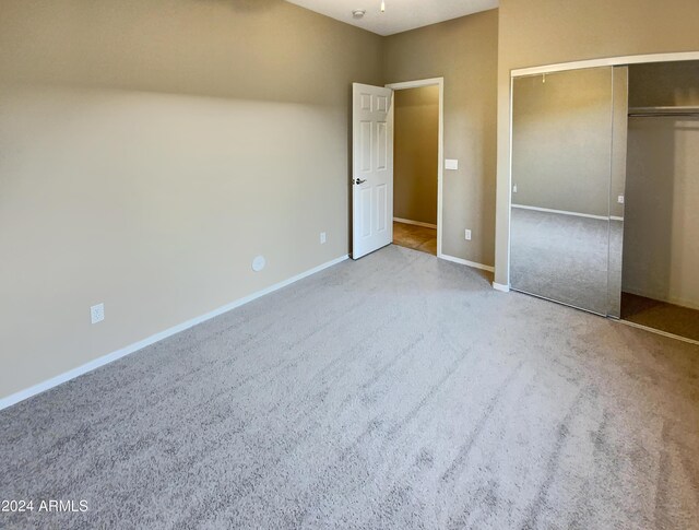 unfurnished bedroom featuring light colored carpet and a closet