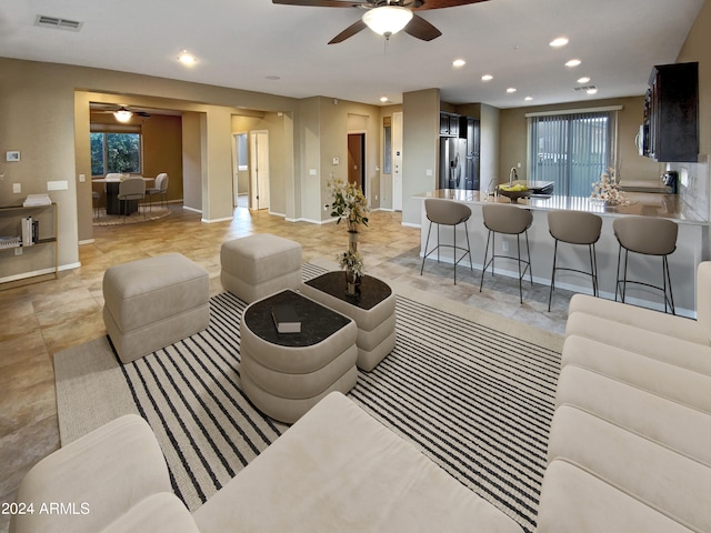 living room with ceiling fan and a healthy amount of sunlight