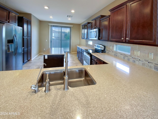 kitchen with appliances with stainless steel finishes, backsplash, and sink