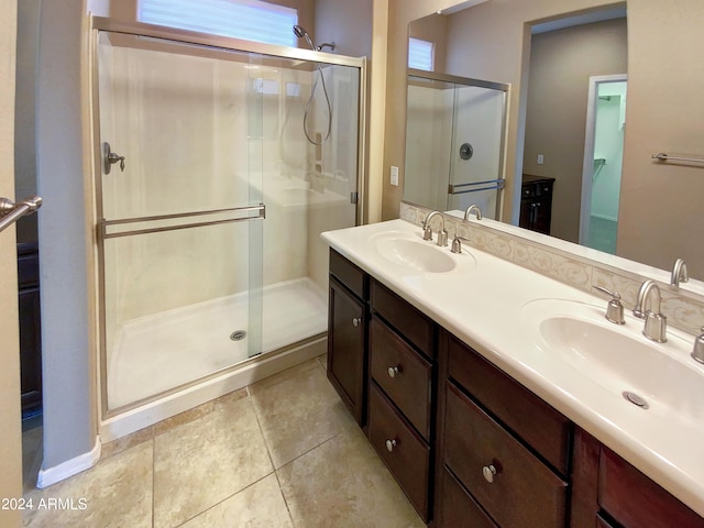 bathroom featuring tile patterned flooring, an enclosed shower, and vanity