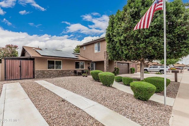 1121 W Mission Dr, Chandler, AZ 85224 - view of front of home with stucco siding, a gate, solar panels, stone siding, and concrete driveway