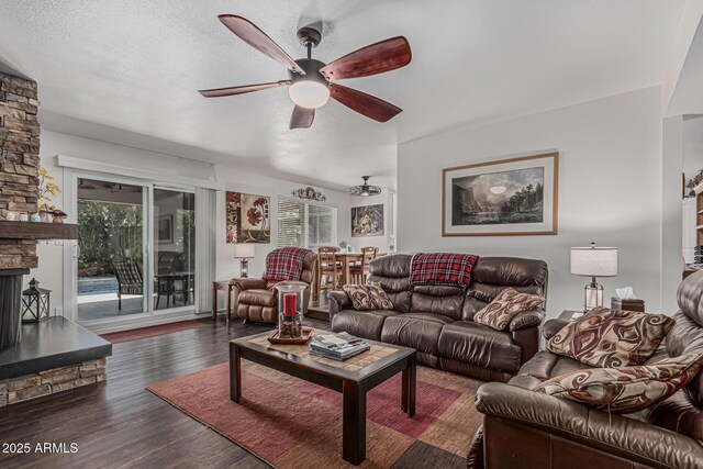 1121 W Mission Dr, Chandler, AZ 85224 - living room featuring a ceiling fan, a stone fireplace, dark wood-style floors, and a textured ceiling
