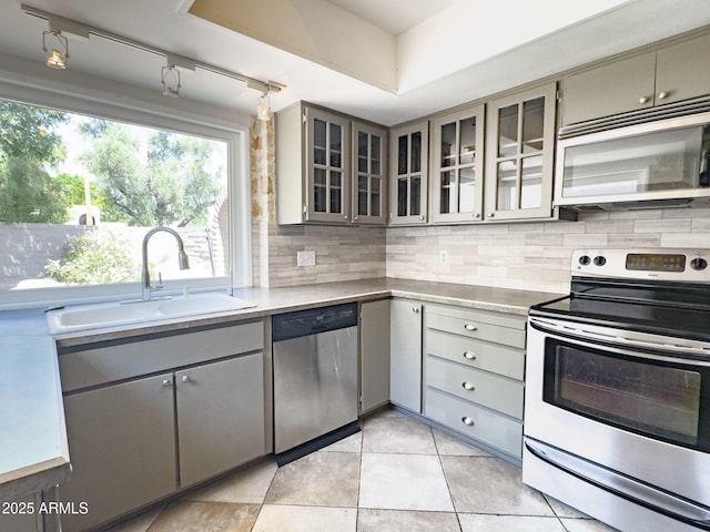 7770 E Camelback Rd Unit 23, Scottsdale, AZ 85251 - kitchen featuring appliances with stainless steel finishes, gray cabinets, a sink, tasteful backsplash, and light countertops