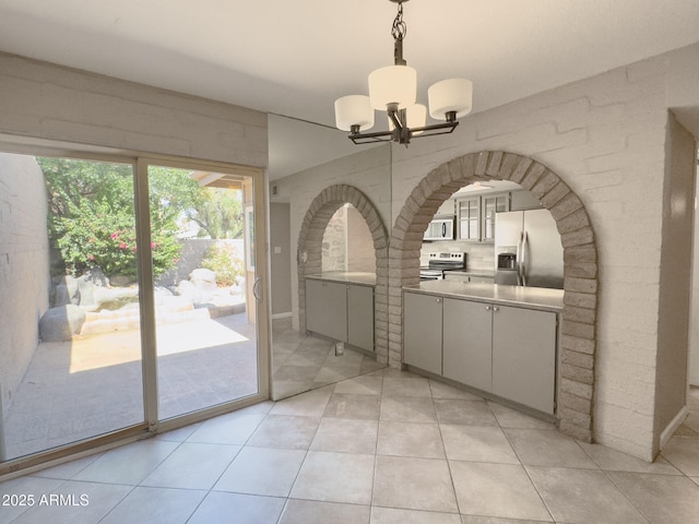 7770 E Camelback Rd Unit 23, Scottsdale, AZ 85251 - unfurnished dining area featuring a chandelier, light tile patterned floors, and arched walkways