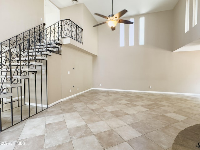 7770 E Camelback Rd Unit 23, Scottsdale, AZ 85251 - unfurnished living room with a high ceiling, ceiling fan, stairs, tile patterned floors, and baseboards