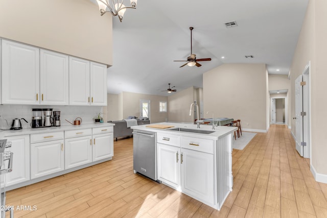 kitchen featuring white cabinetry, sink, stainless steel dishwasher, lofted ceiling, and ceiling fan with notable chandelier