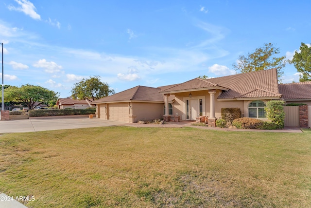 mediterranean / spanish-style home featuring a garage and a front lawn