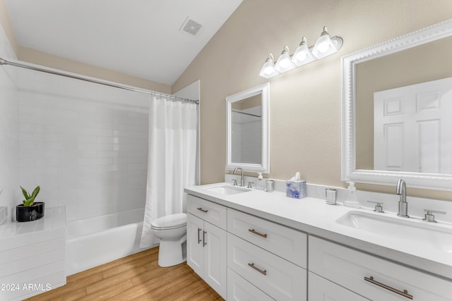 full bathroom featuring hardwood / wood-style floors, vanity, lofted ceiling, shower / bath combination with curtain, and toilet