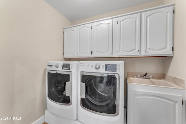 laundry area with washer and clothes dryer, cabinets, and sink