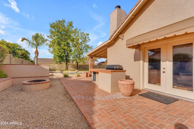 view of patio with grilling area, french doors, and an outdoor kitchen