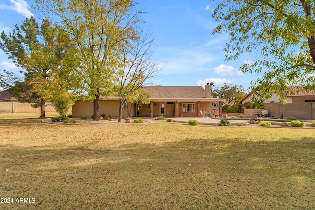 view of front of house with a front yard and a patio area