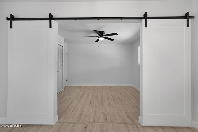 811 E Brown St, Phoenix, AZ 85020 - empty room featuring a barn door, ceiling fan, and wood finished floors