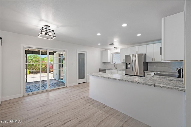 811 E Brown St, Phoenix, AZ 85020 - kitchen featuring stainless steel fridge with ice dispenser, stove, light wood-type flooring, a peninsula, and light stone counters