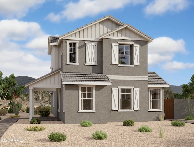 view of front of home featuring fence, board and batten siding, and stucco siding